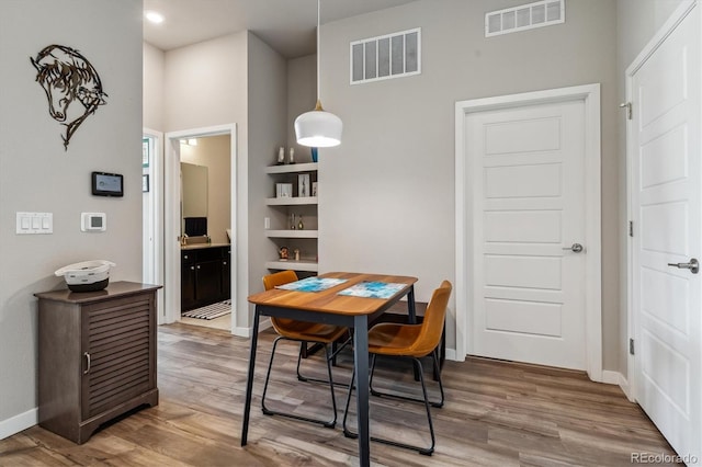 dining area with wood finished floors, visible vents, and baseboards