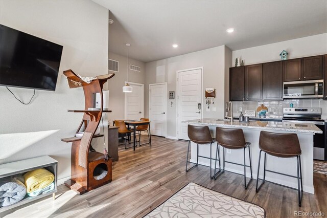 kitchen with decorative backsplash, dark wood-style flooring, visible vents, and appliances with stainless steel finishes