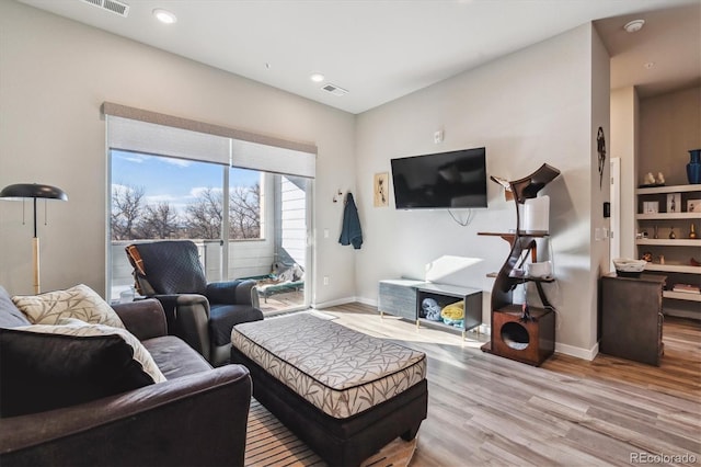 living room with recessed lighting, light wood-type flooring, baseboards, and visible vents