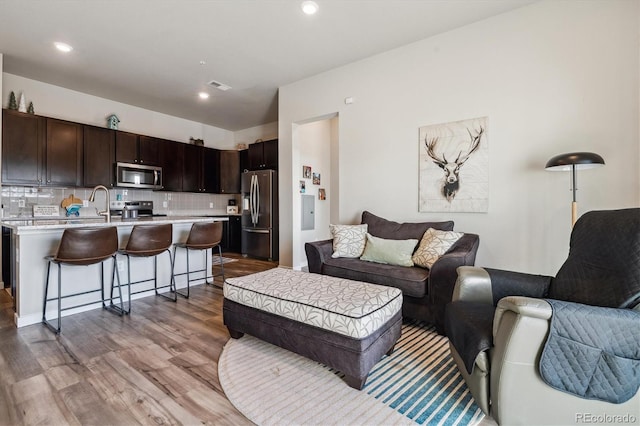 living area featuring recessed lighting, visible vents, and wood finished floors