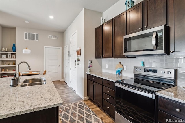 kitchen with visible vents, stainless steel appliances, decorative backsplash, and a sink