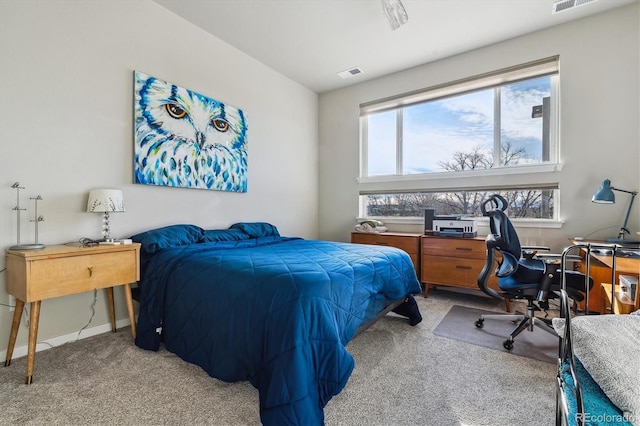 bedroom featuring visible vents, light carpet, and baseboards