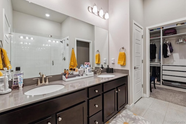 bathroom featuring tile patterned flooring, a shower stall, double vanity, and a sink