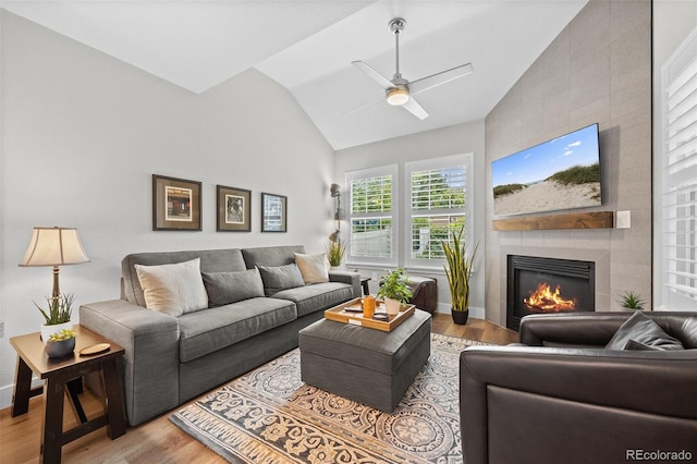 2528 Concord Cir, Lafayette, CO 80026 - living area featuring wood finished floors, a tiled fireplace, ceiling fan, and high vaulted ceiling