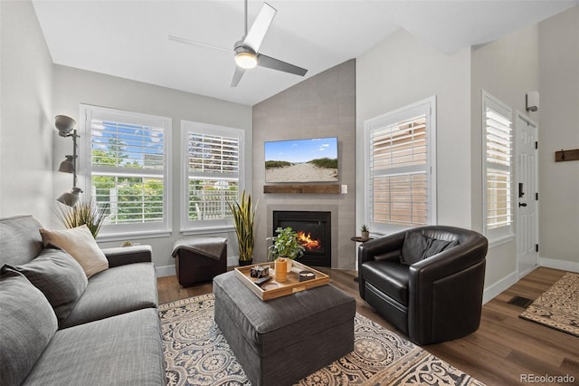 2528 Concord Cir, Lafayette, CO 80026 - living area featuring lofted ceiling, wood finished floors, a tiled fireplace, and ceiling fan