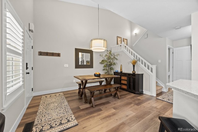 2528 Concord Cir, Lafayette, CO 80026 - dining room featuring stairway, light wood finished floors, and a towering ceiling