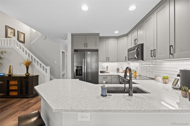 2528 Concord Cir, Lafayette, CO 80026 - kitchen with stainless steel fridge, gray cabinets, a peninsula, light stone counters, and recessed lighting