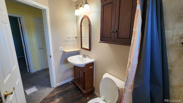 bathroom with hardwood / wood-style flooring, vanity, and toilet