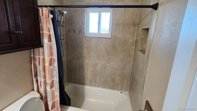 bathroom with toilet and shower / tub combo with curtain