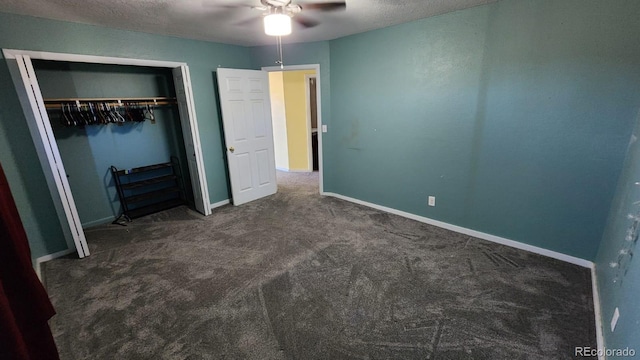 unfurnished bedroom with dark colored carpet, a closet, ceiling fan, and a textured ceiling