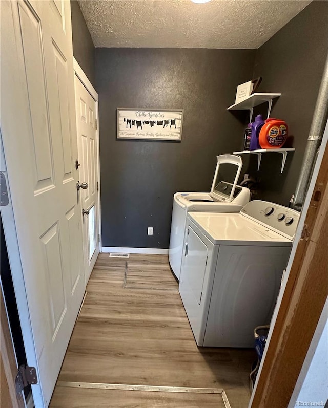 98 Baylor Dr, Buena Vista, CO 81211 - laundry area with washing machine and clothes dryer, a textured ceiling, light wood-type flooring, and baseboards