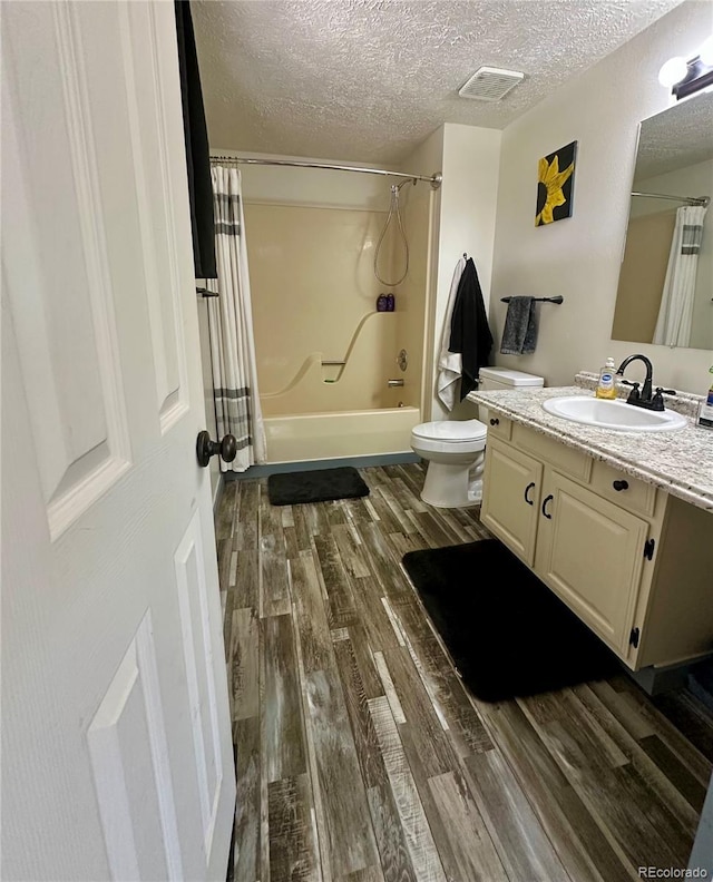 98 Baylor Dr, Buena Vista, CO 81211 - full bath featuring vanity, wood finished floors, shower / bath combo, a textured ceiling, and toilet