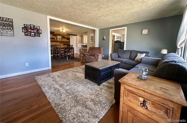 98 Baylor Dr, Buena Vista, CO 81211 - living area featuring dark wood-style floors, a textured ceiling, and baseboards