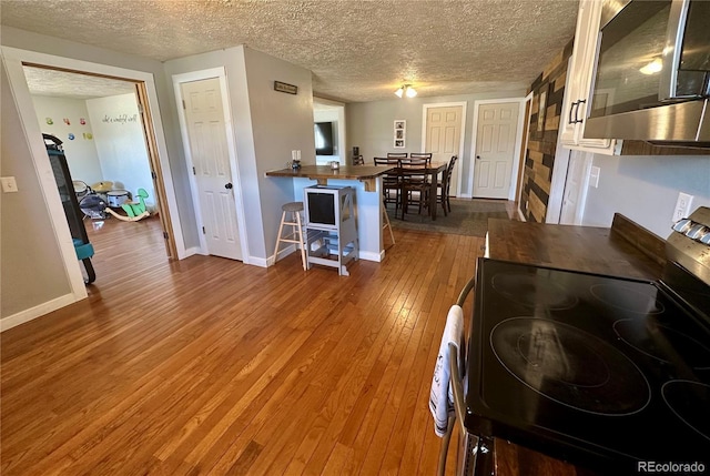 98 Baylor Dr, Buena Vista, CO 81211 - kitchen with stainless steel appliances, wood counters, hardwood / wood-style floors, a textured ceiling, and baseboards