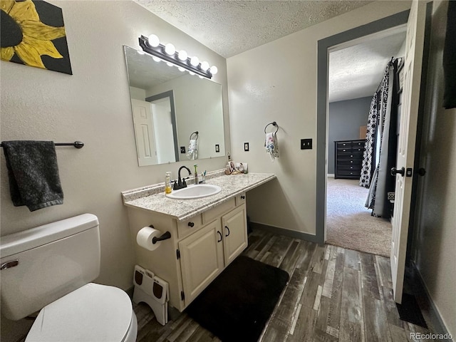 98 Baylor Dr, Buena Vista, CO 81211 - bathroom featuring wood finished floors, toilet, vanity, a textured ceiling, and baseboards