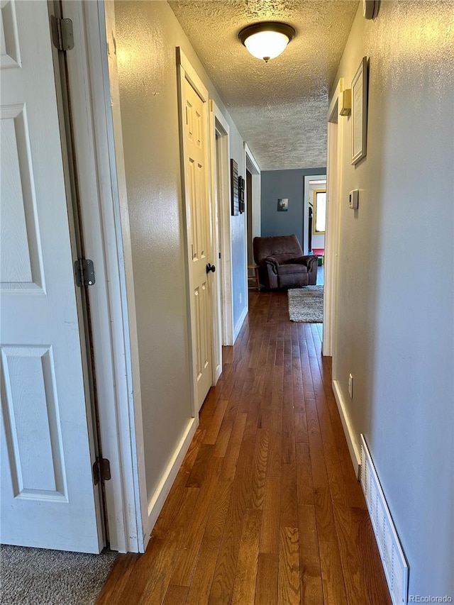 98 Baylor Dr, Buena Vista, CO 81211 - hallway featuring a textured ceiling, dark wood-style floors, and baseboards