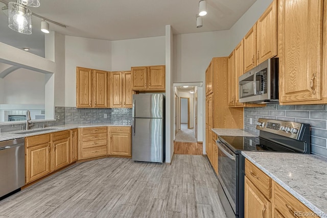 1838 Mountain Daisy Ct, Highlands Ranch, CO 80129 - kitchen featuring appliances with stainless steel finishes, decorative backsplash, light wood-type flooring, and light stone counters