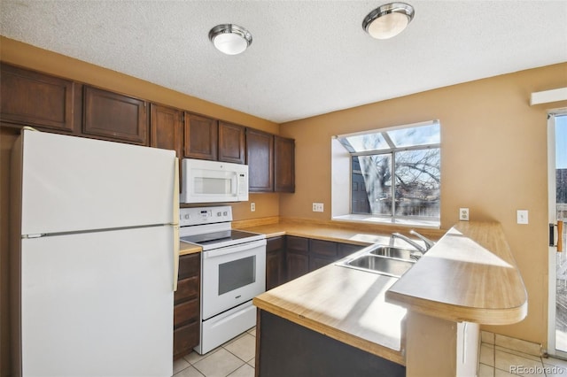 kitchen with light tile patterned floors, white appliances, a textured ceiling, and sink