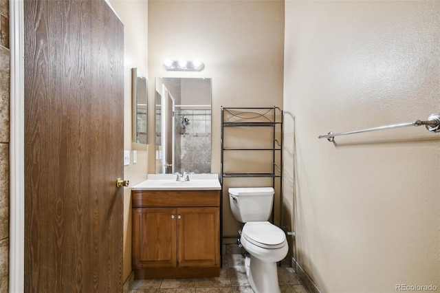 bathroom with toilet, vanity, and tile patterned floors