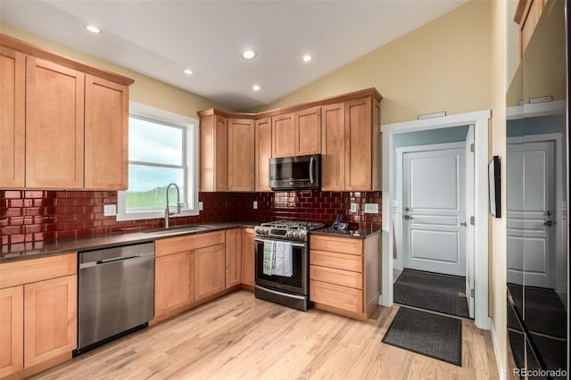 19500 Wedemeyer Rd, Kiowa, CO 80117 - kitchen featuring appliances with stainless steel finishes, dark countertops, light wood-type flooring, vaulted ceiling, and recessed lighting