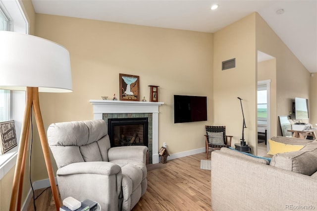 19500 Wedemeyer Rd, Kiowa, CO 80117 - living area featuring light wood-style floors, a tile fireplace, plenty of natural light, vaulted ceiling, and recessed lighting