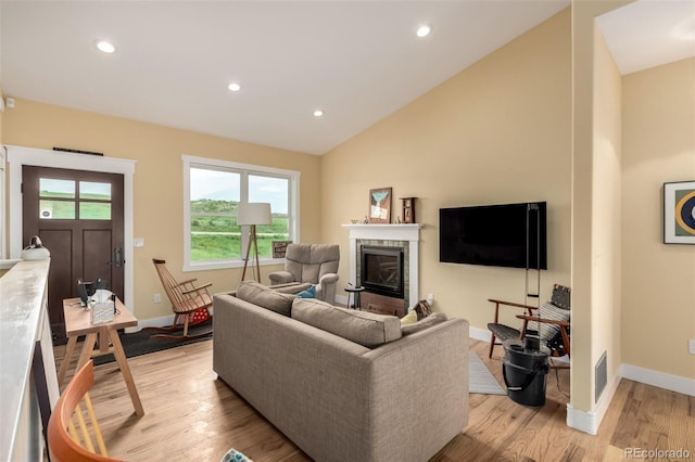 19500 Wedemeyer Rd, Kiowa, CO 80117 - living area with light wood-type flooring, a glass covered fireplace, recessed lighting, and lofted ceiling
