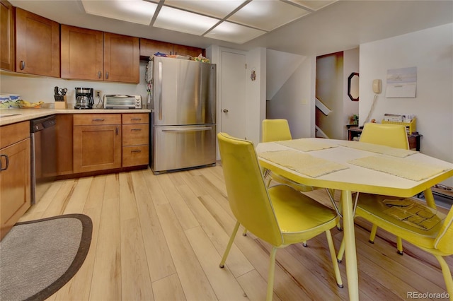 kitchen featuring dishwashing machine, stainless steel fridge, and light hardwood / wood-style floors