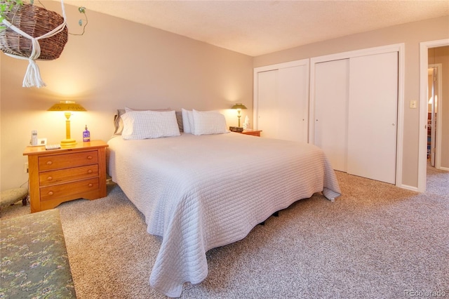 bedroom featuring multiple closets and carpet floors