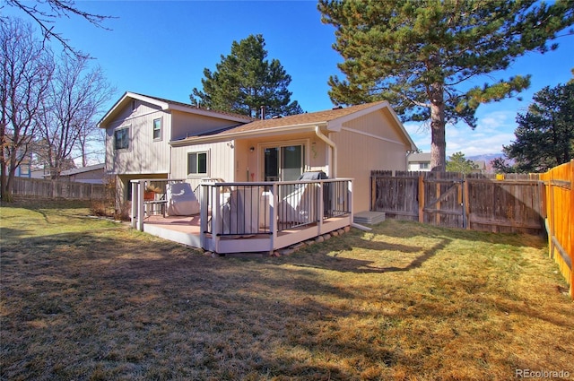 rear view of house featuring a wooden deck and a lawn