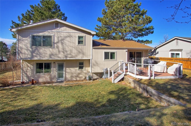 rear view of house featuring a deck and a lawn