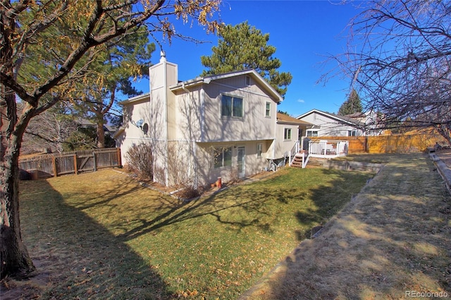 rear view of property with a deck and a lawn