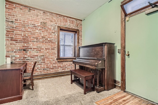 carpeted home office featuring a textured ceiling and brick wall