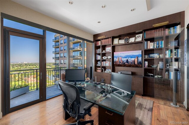 home office with light hardwood / wood-style flooring