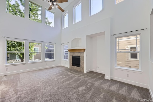 3514 E 141st Dr, Thornton, CO 80602 - unfurnished living room with carpet floors, ceiling fan, a high ceiling, and a tile fireplace