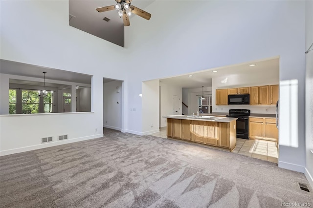 3514 E 141st Dr, Thornton, CO 80602 - kitchen with black appliances, ceiling fan, light colored carpet, a kitchen island with sink, and light countertops