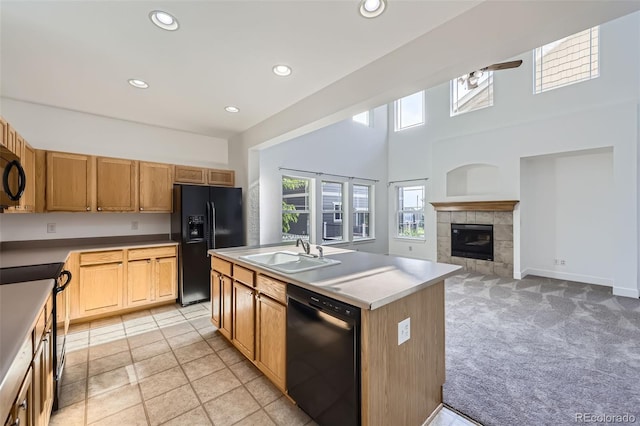 3514 E 141st Dr, Thornton, CO 80602 - kitchen with black appliances, a fireplace, recessed lighting, a center island with sink, and light colored carpet