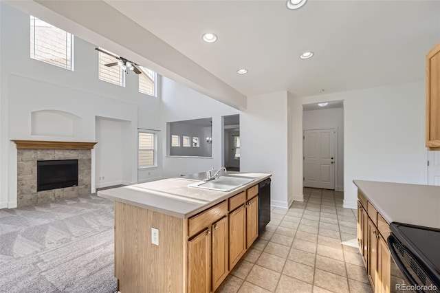 3514 E 141st Dr, Thornton, CO 80602 - kitchen featuring black appliances, ceiling fan, light countertops, a fireplace, and a center island with sink
