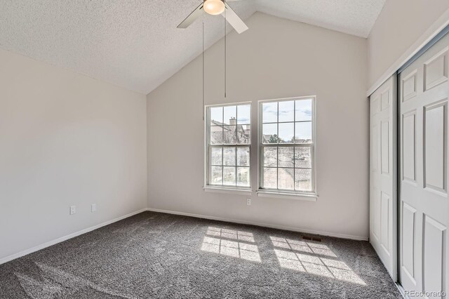 unfurnished bedroom with carpet flooring, a textured ceiling, ceiling fan, high vaulted ceiling, and baseboards