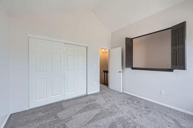 unfurnished bedroom with carpet, baseboards, a closet, high vaulted ceiling, and a textured ceiling