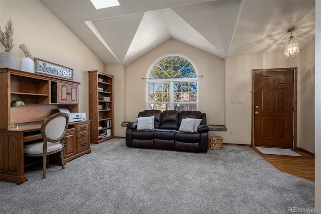 home office featuring vaulted ceiling with skylight and light colored carpet