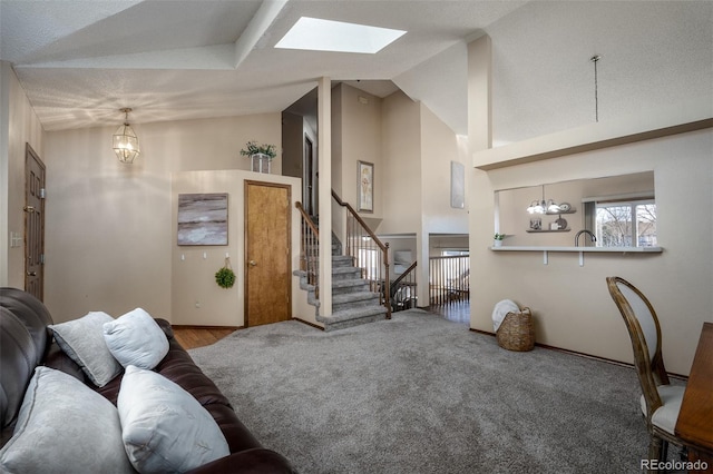 carpeted living area featuring a chandelier, stairway, a skylight, and high vaulted ceiling