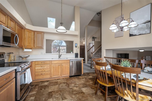 kitchen with a sink, stainless steel appliances, light countertops, pendant lighting, and a chandelier