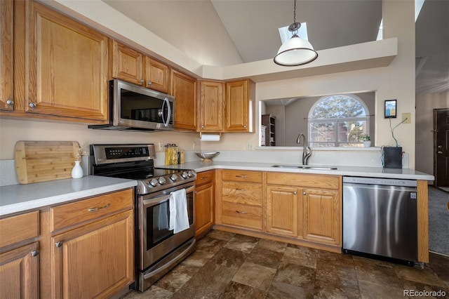 kitchen with lofted ceiling, a sink, stainless steel appliances, light countertops, and pendant lighting