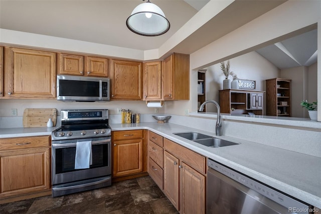 kitchen featuring a sink, stainless steel appliances, brown cabinetry, and light countertops