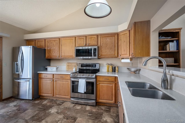 kitchen featuring brown cabinets, a sink, stainless steel appliances, light countertops, and lofted ceiling