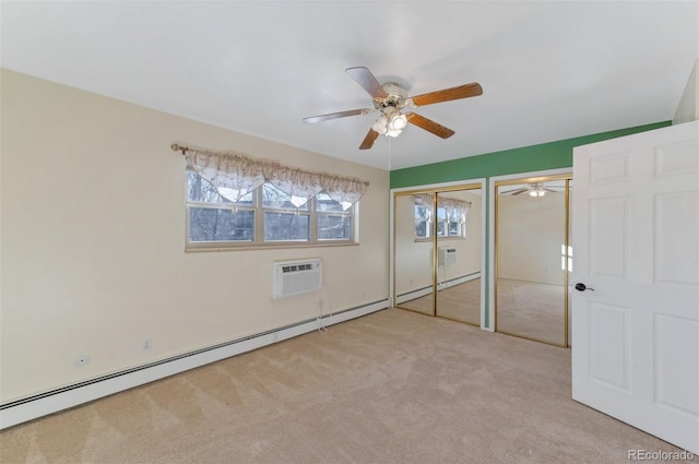 unfurnished bedroom with light carpet, an AC wall unit, a baseboard radiator, two closets, and ceiling fan