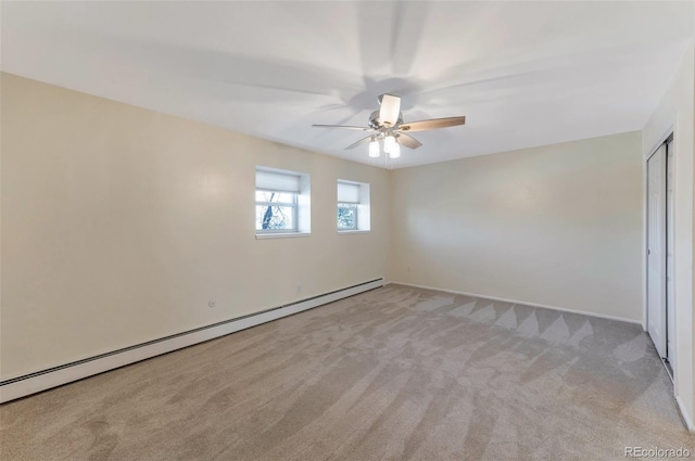 empty room with ceiling fan, light colored carpet, and baseboard heating