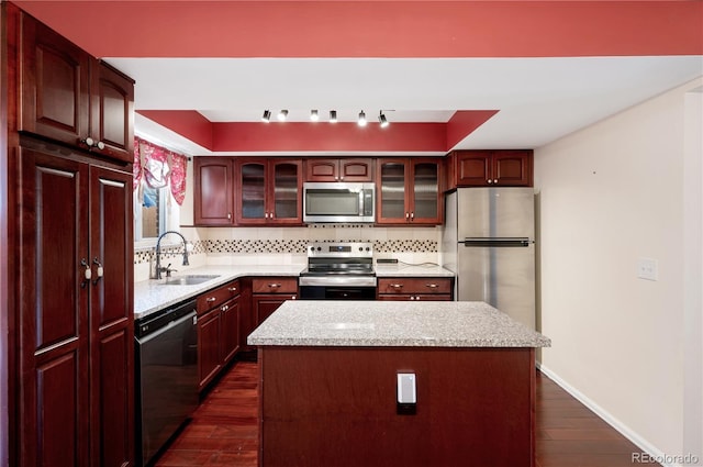 kitchen featuring a kitchen island, a raised ceiling, sink, dark hardwood / wood-style flooring, and stainless steel appliances