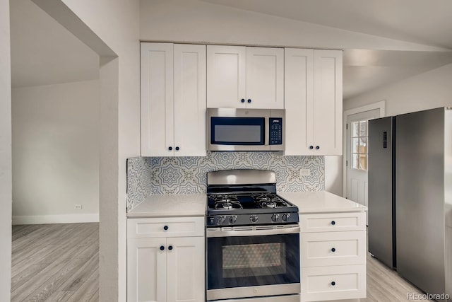 4435-4455 Elizabeth, Denver, CO 80206 - kitchen featuring stainless steel appliances, light countertops, light wood finished floors, white cabinets, and lofted ceiling