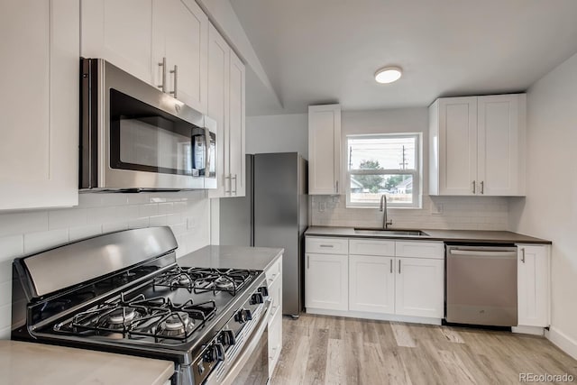 4435-4455 Elizabeth, Denver, CO 80206 - kitchen with stainless steel appliances, light wood-style flooring, white cabinetry, decorative backsplash, and dark countertops